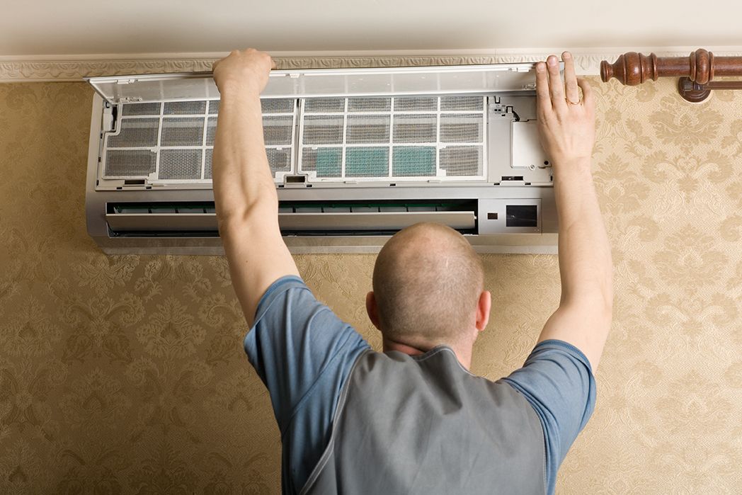 Man Performing HVAC Repair in Boca Raton on wall AC unit