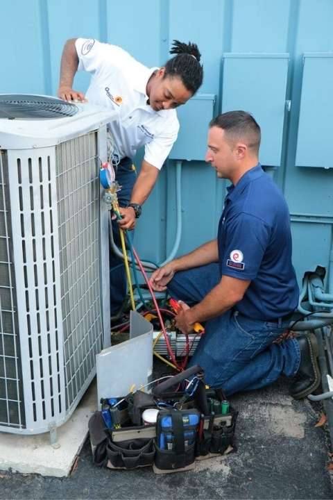 Two men in the middle of an air conditioner replacement in Pompano Beach