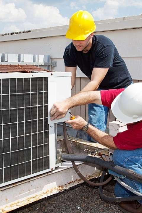 Two men repairing a Commercial Air Conditioning unit in Boynton Beach 